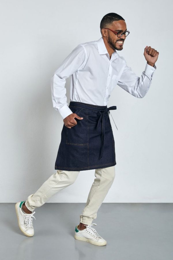 Homem vestido com um avental de ganga de cintura, uma camisa branca e umas calças claras para ser usado como Uniforme de cozinha fabricado pela Unifardas