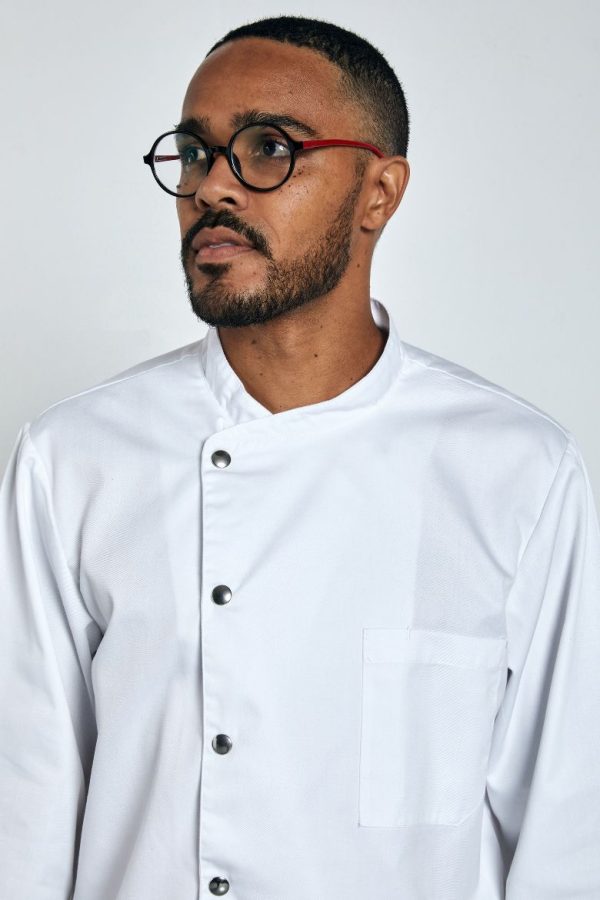 Cozinheiro vestido com uma jaleca de manga comprida branca para ser usada como Uniforme para Hotelaria e fabricada pela Unifardas
