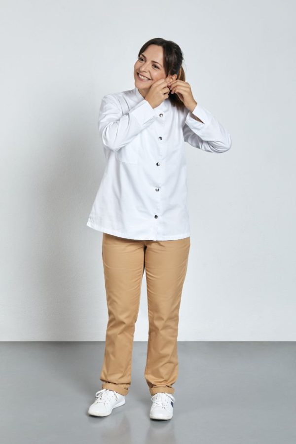 Cozinheira vestida com uma jaleca feminina branca para ser usada como farda para cozinha fabricada pela Unifardas