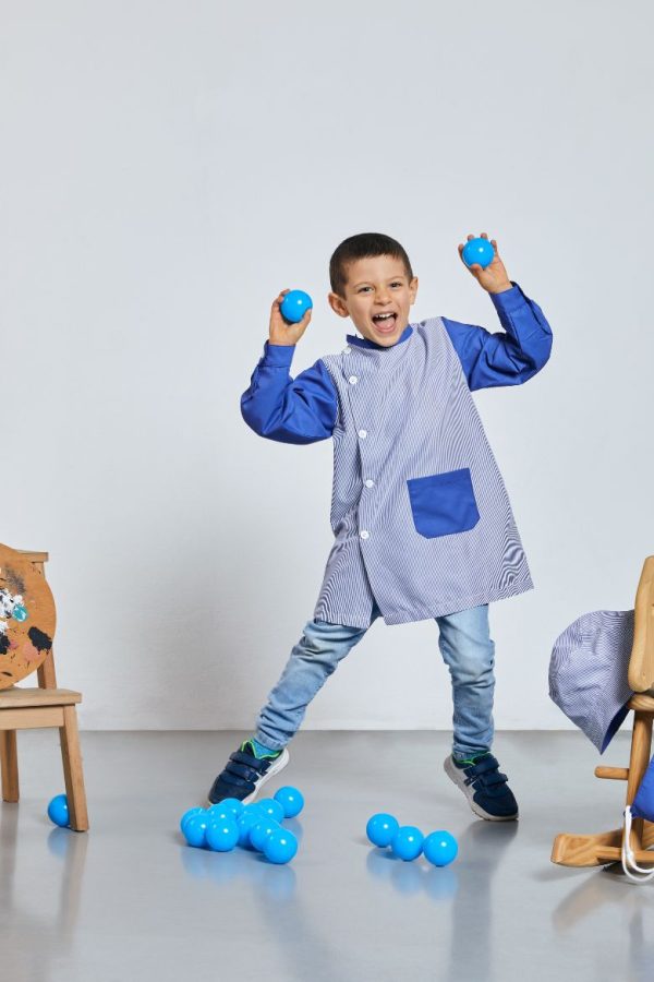 Menino vestido com uma bata escolar para menino na cor azul fabricada pela Unifardas