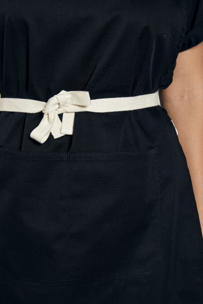 Pormenor de aperto de uma bata avental preta para ser usada como Uniforme profissional fabricada pela Unifardas