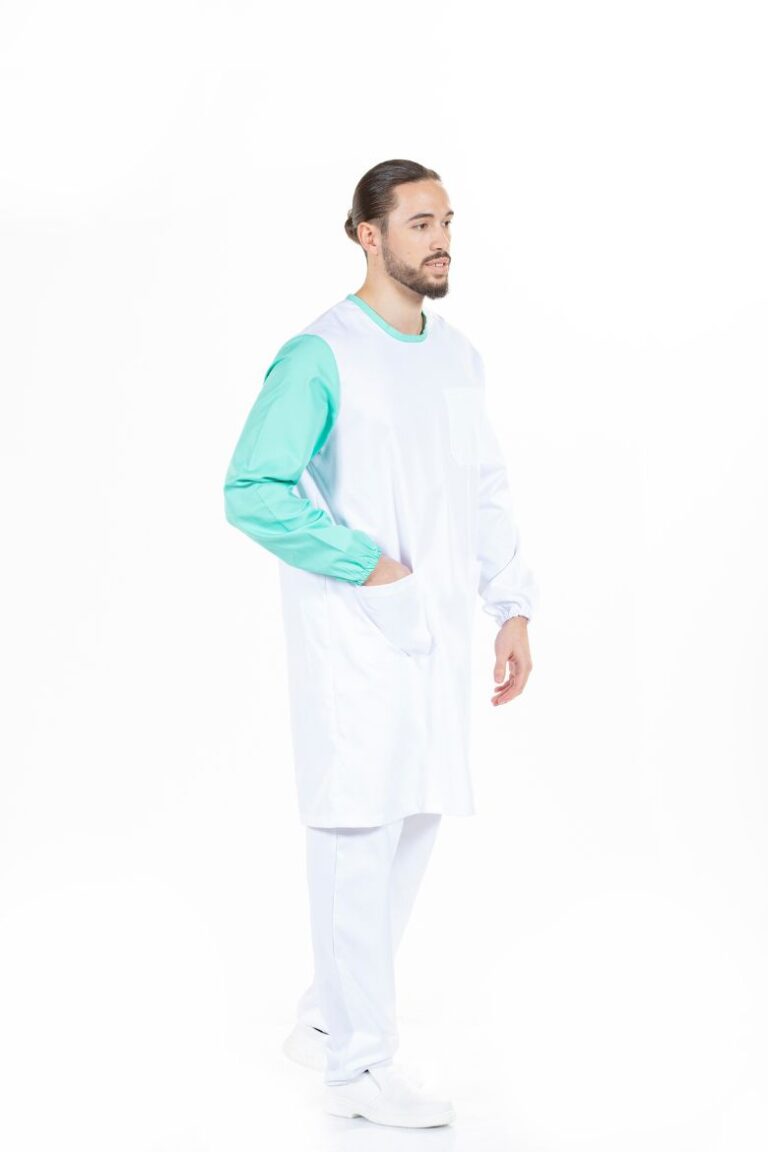 Trabalhador da área da saúde vestido com uma bata médica unissexo branca com contraste a verde fabricada pela Unifardas