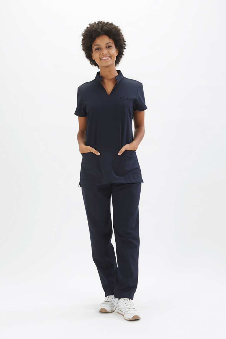 Senhora vestida com calça para enfermeira de cor azul marinha para ser usada como Uniforme para a área da saúde fabricado pela unifardas