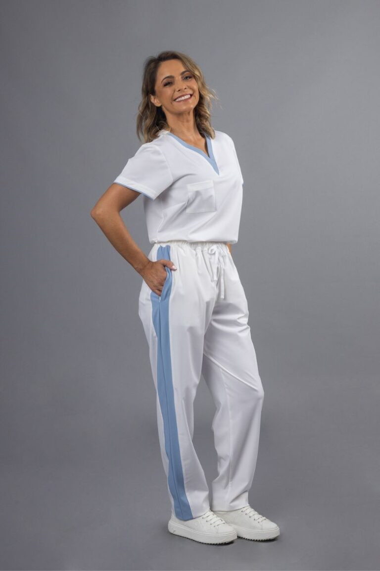 Profissional de Saúde vestida com uma túnica branca com contraste em azul na gola e uma calça para spa branca com contraste em azul para ser usada como Uniforme Profisisonal