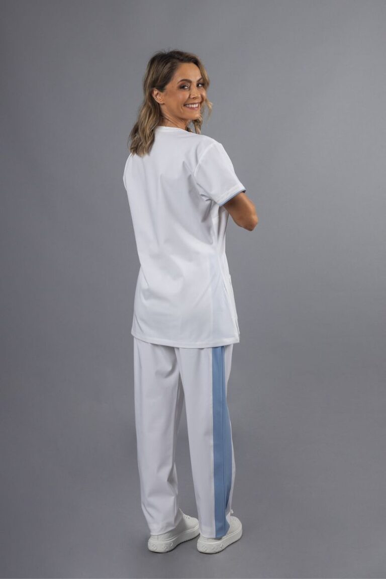 Senhora vestida com uma calça para spa de cor branca com uma tira azul na perna usada para roupa de trabalho para a área da saúde e bem-estar