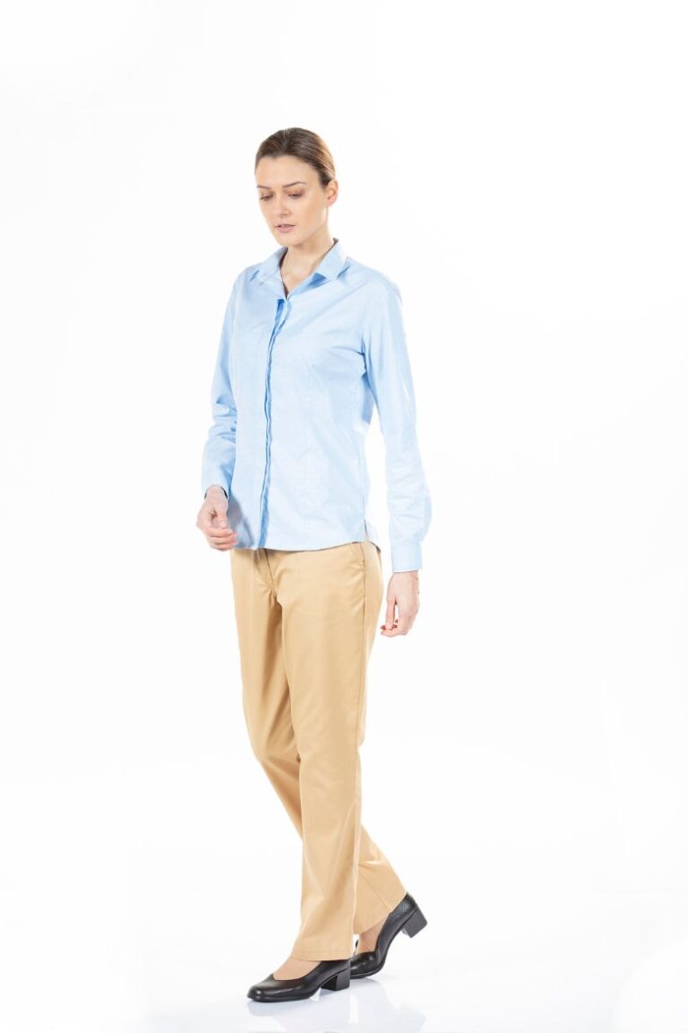 Trabalhadora vestida com uma camisa azul e umas calças profissionais para serem usadas como roupa de trabalho fabricada pela Unifardas