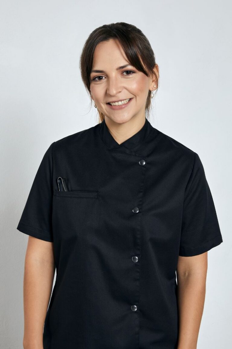 Cozinheira vestida com uma Jaleca feminina de manga curta para ser usada como uniforme de cozinha da Unifardas