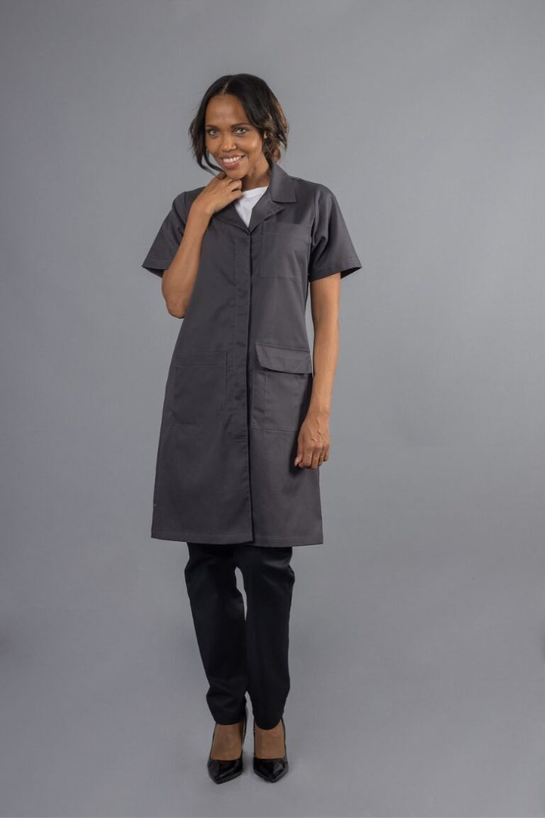 Trabalhadora da área da indústria vestida com uma bata cinza de trabalho fabricada pela Unifardas