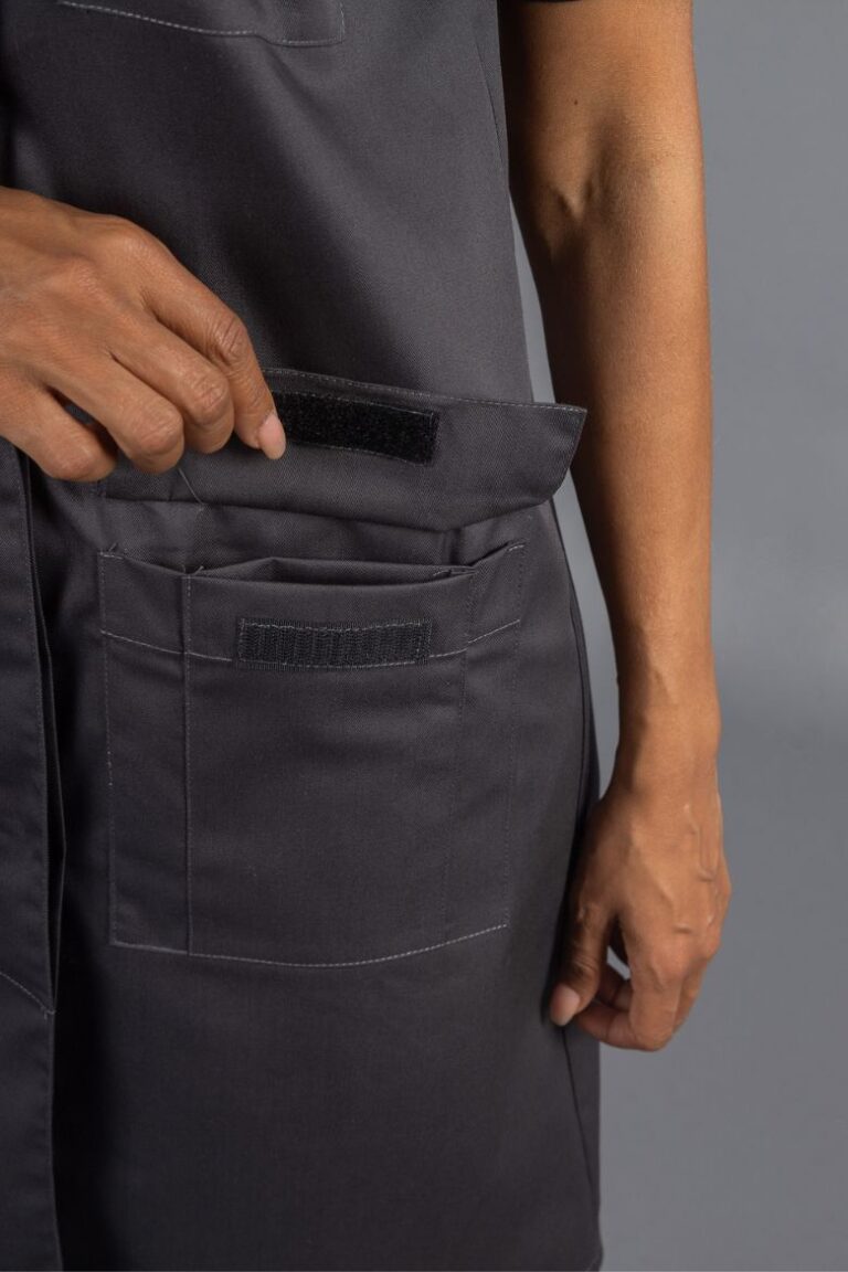 Pormenor dos bolsos da bata cinza de trabalho para ser usada como Uniforme Profissional Feminino para a área da Indústria