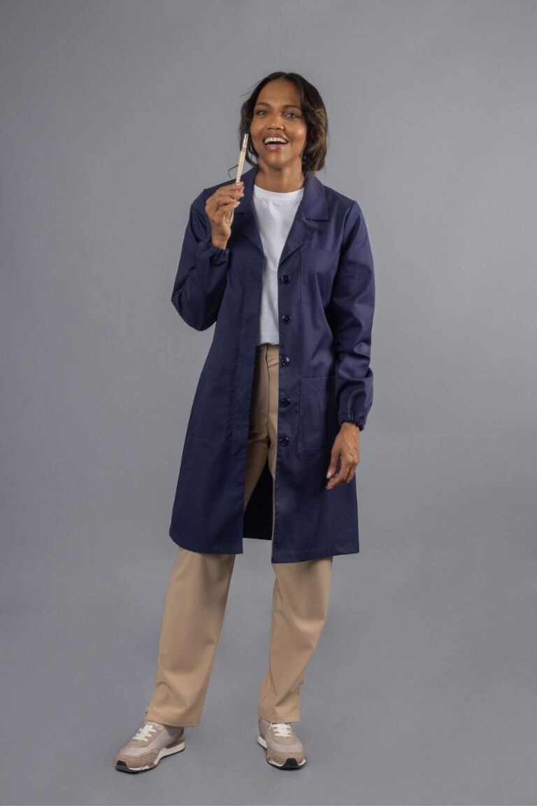 Trabalhadora da Indústria vestida com uma Bata de Senhora com manga comprida de cor azul marinha para ser usada como peça de roupa de trabalho fabricada pela Unifardas