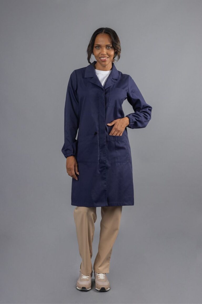 Trabalhadora da área da indústria vestida com uma bata de Senhora de manga comprida de cor azul marinha usada como vestuário profissional fabricada pela unifardas