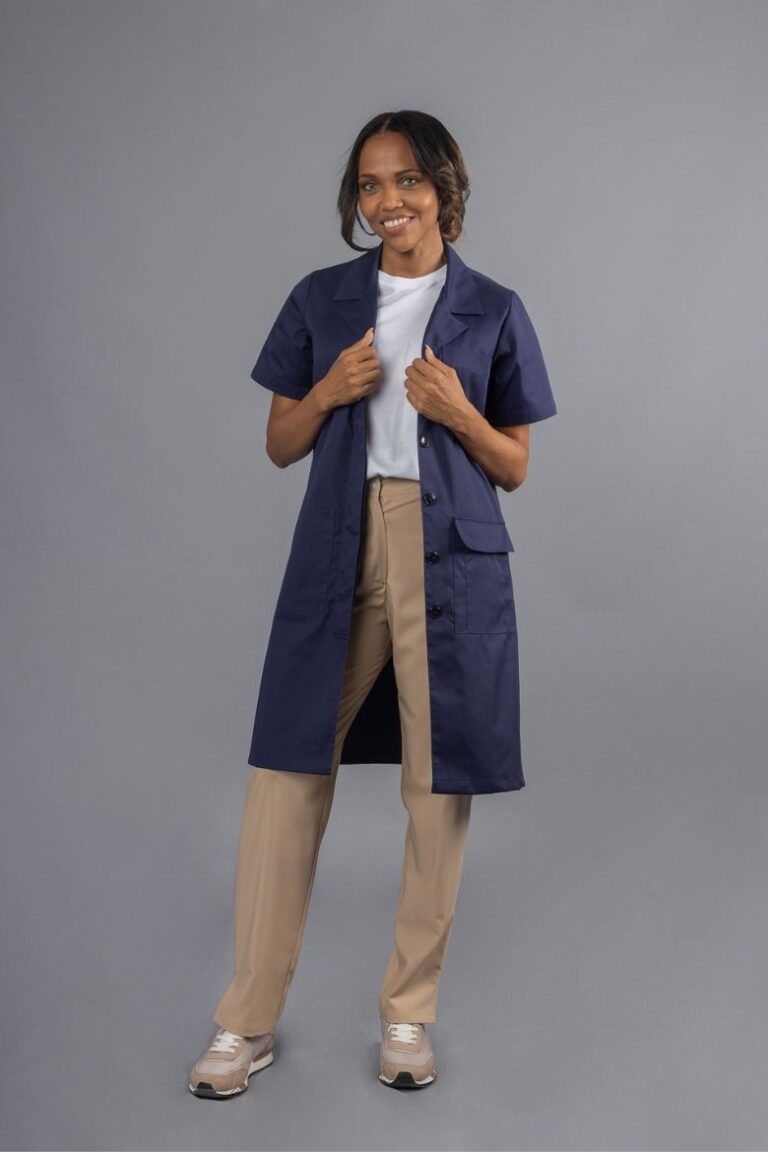Trabalhadora vestida com uma bata de senhora com manga curta para indústria na cor azul marinha para ser usada como peça para Uniforme Profissional fabricada pela Unifardas