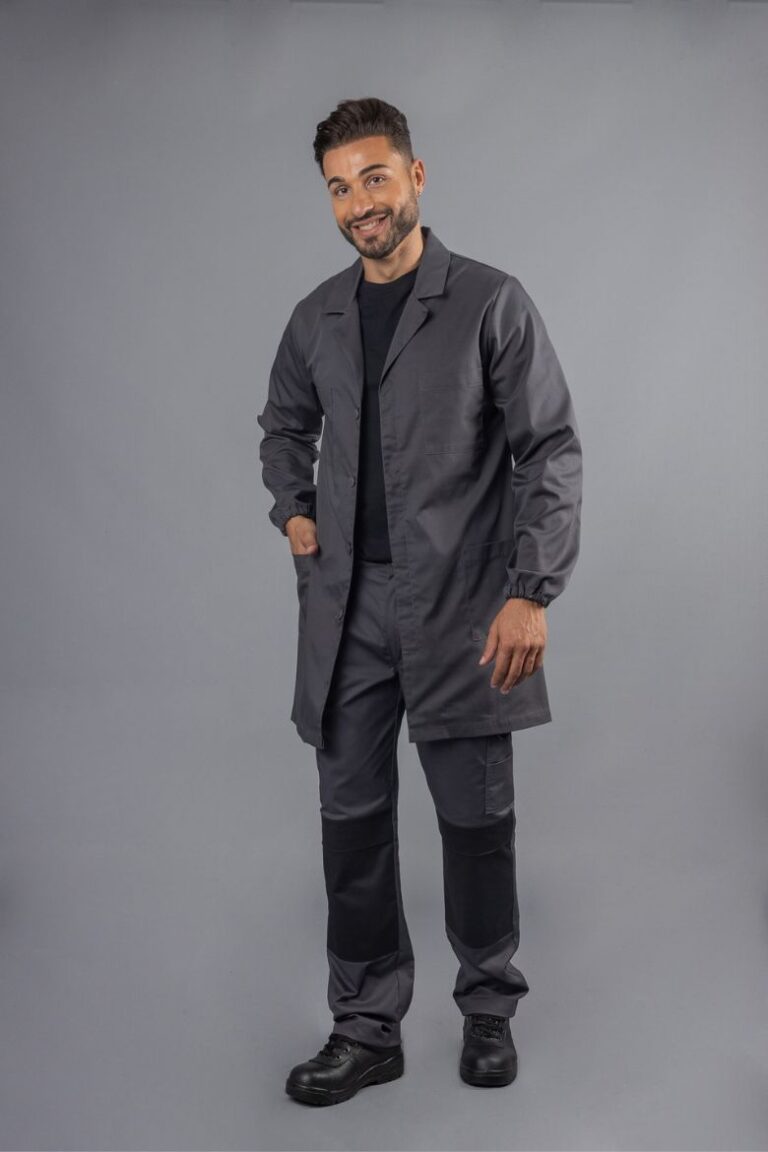 Homem vestido com umas calças cinzentas com contraste a preto e vermelho e com uma bata industrial de trabalho para ser usada como Uniforme Profissional para a área da indústria fabricada pela Unifardas