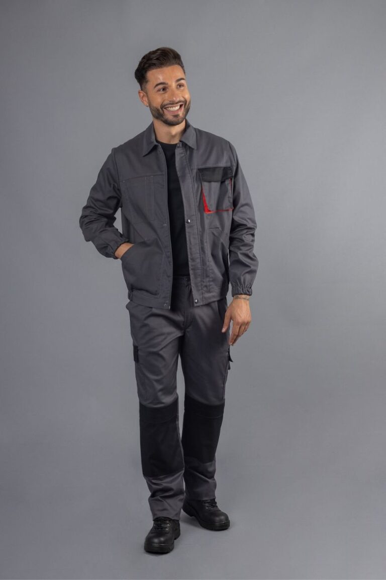 Trabalhador vestido com um casaco de trabalho para indústria na cor cinza com contraste a preto e vermelho.
