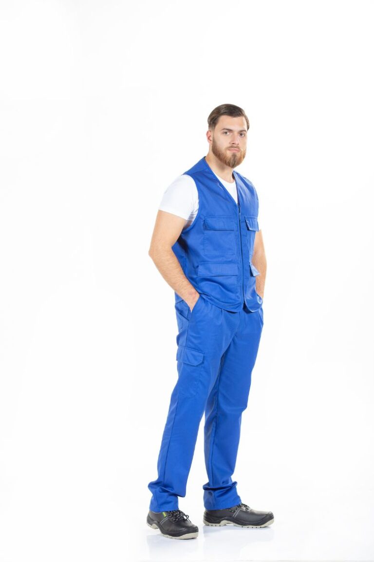 Trabalhador da área da Indústria vestido com um colete para fardamento e uma calça azul de trabalho fabricada pela Unifardas