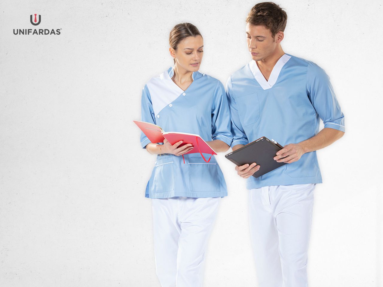 Enfermeiros vestidos com uma túnica azul e uma calça branca para serem usadas como fardas médicas fabricadas pela Unifardas
