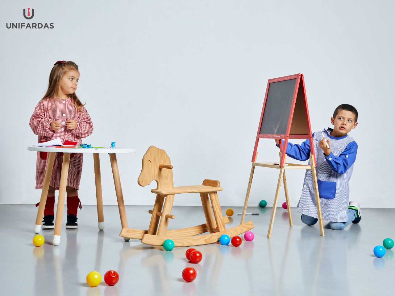 Garçon et fille portant l'une des blouses scolaires développées et fabriquées par Unifardas pour servir d'uniforme scolaire.